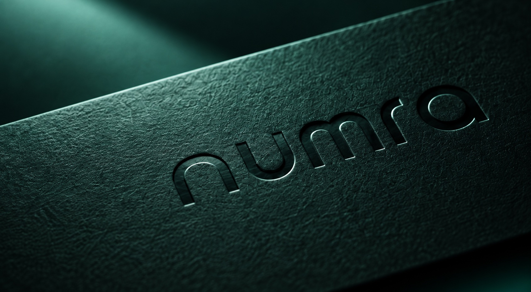 Numra wordmark embossed on dark forest material